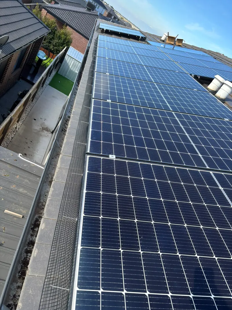 Long array of solar panels with bird proofing mesh on the gutter side