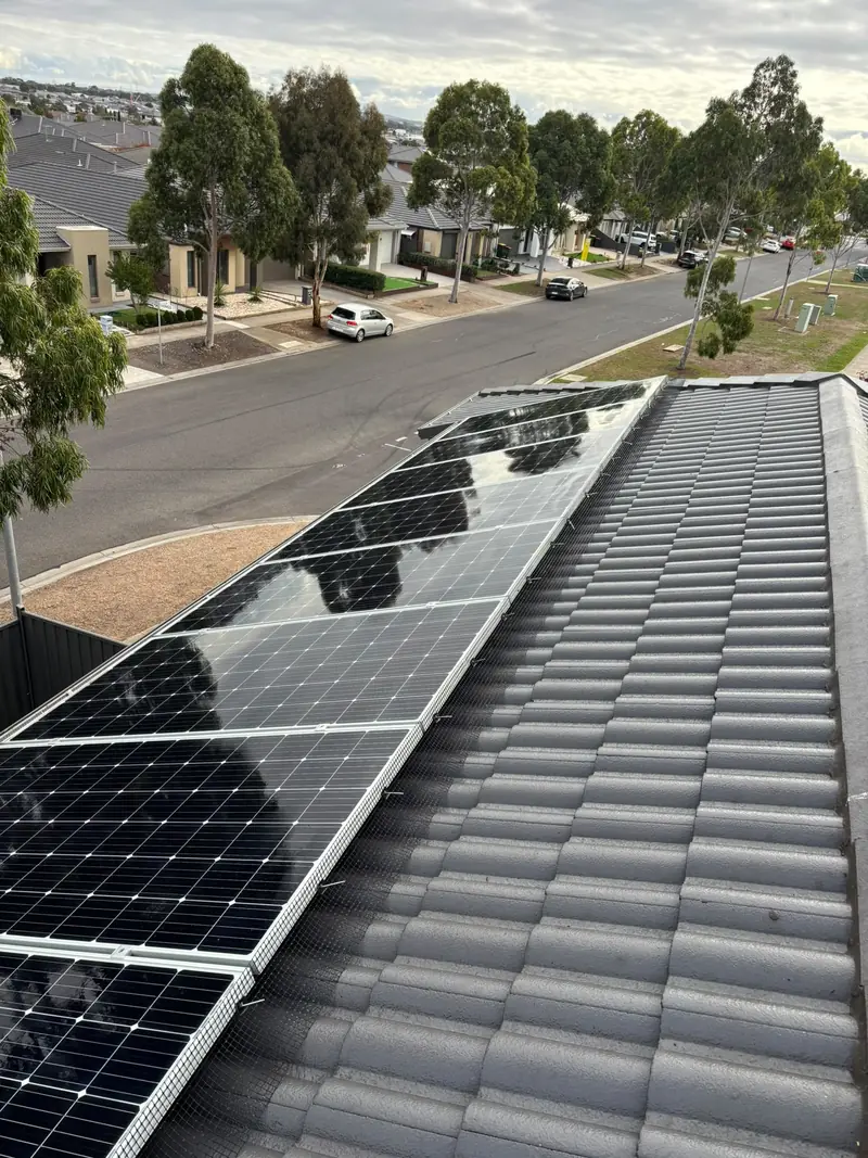 Black mesh fitted under the lower edge of a solar array on a tile roof