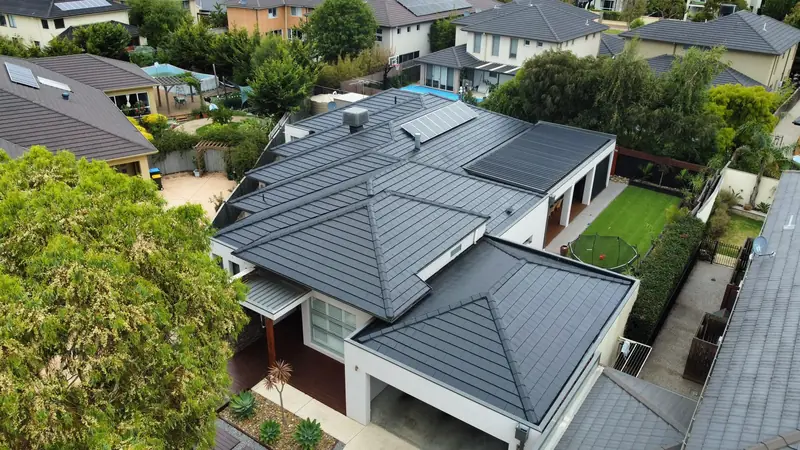 Charcoal tile roof on a home with a double garage and pergola, aerial view