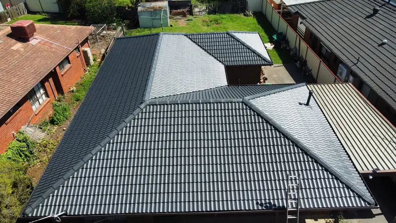 Dark grey tile roof with a patio roof beside it, aerial view