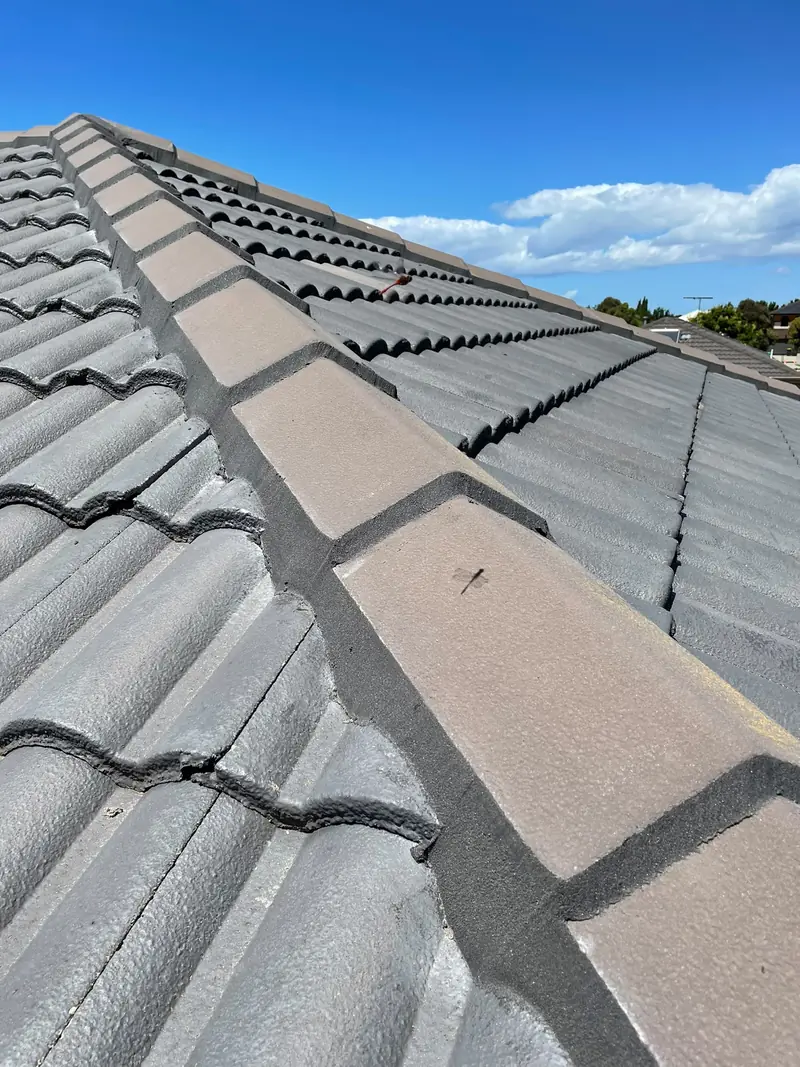 Ridge capping with fresh flexible pointing on a grey concrete tile roof