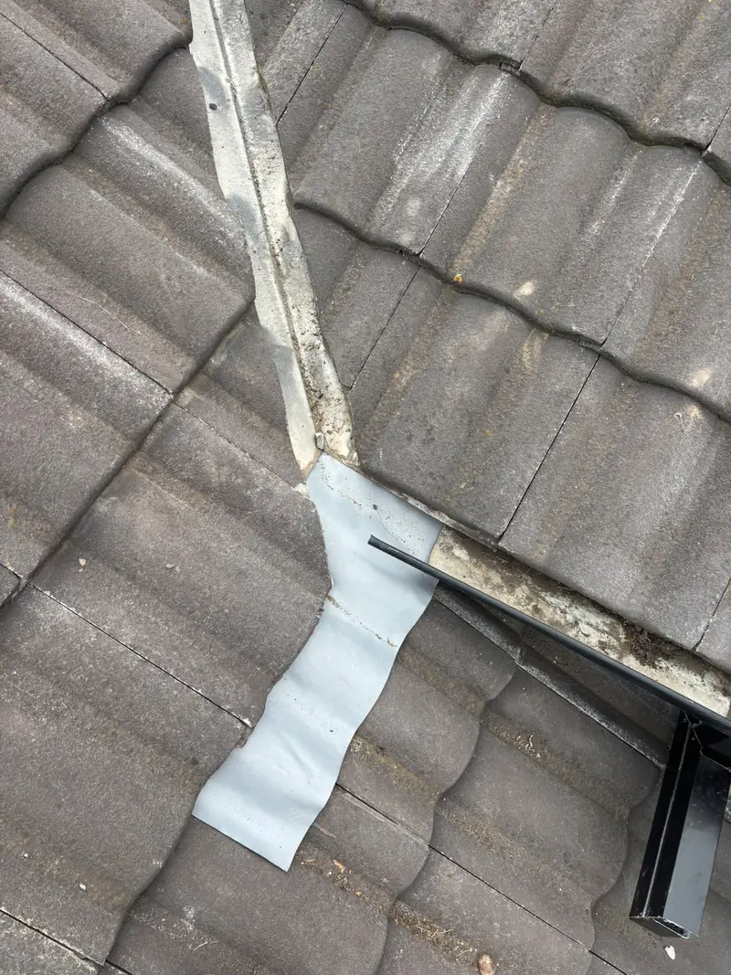 Flashing repair at the base of a tile roof valley using membrane flashing