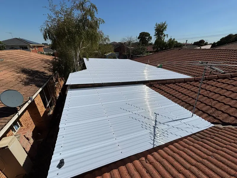 White roof sheeting on a patio beside a red tile roof